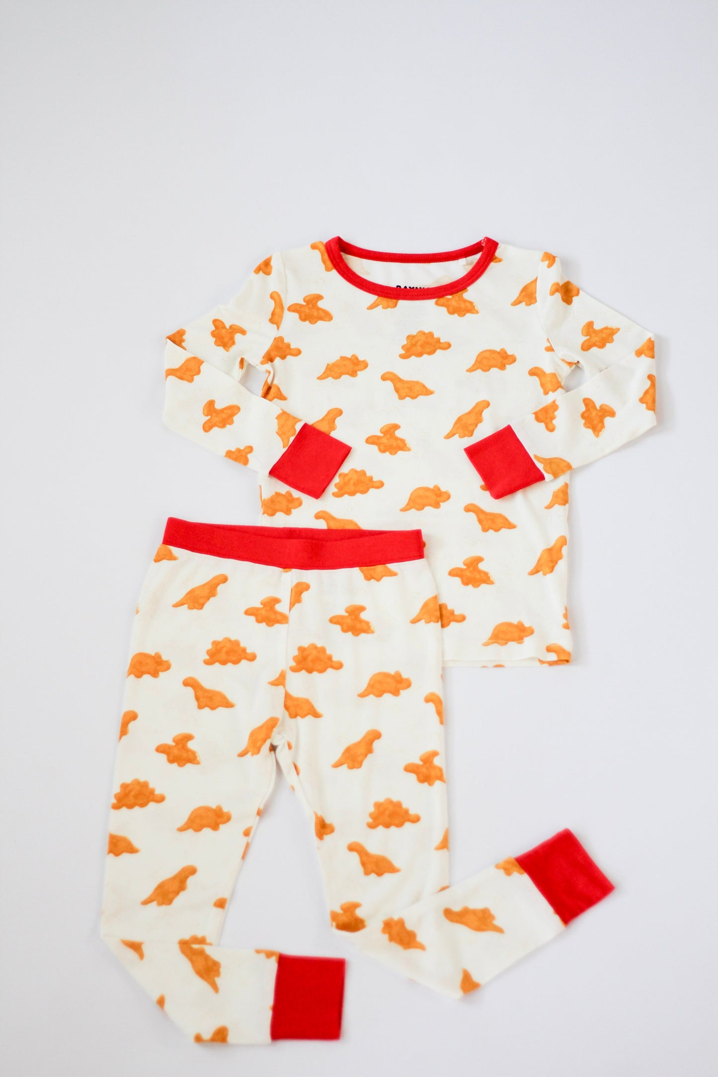 Children's pajama set with dinosaur pattern on a white background