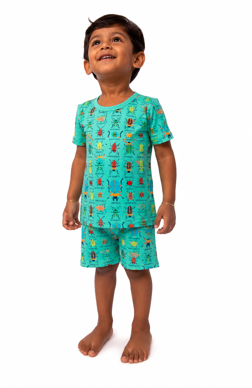 Child wearing a teal pajama set with cartoon characters on a white background