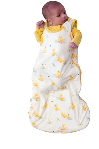 Baby in a duck print double zip sleep sack that is comforts newborns
