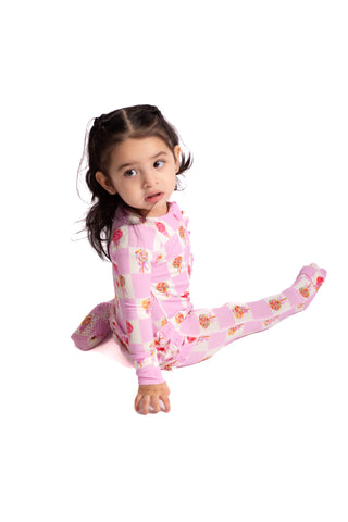 Child wearing pink floral pajamas on a white background