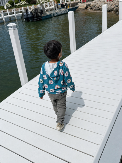 Child walking on a dock by a body of water