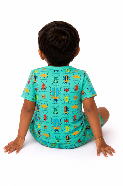 Child wearing a teal outfit with colorful insect patterns on a white background