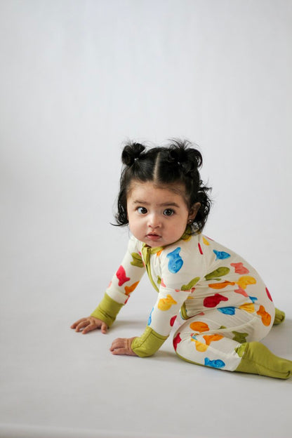 Child wearing a colorful onesie with fish pattern on a white background