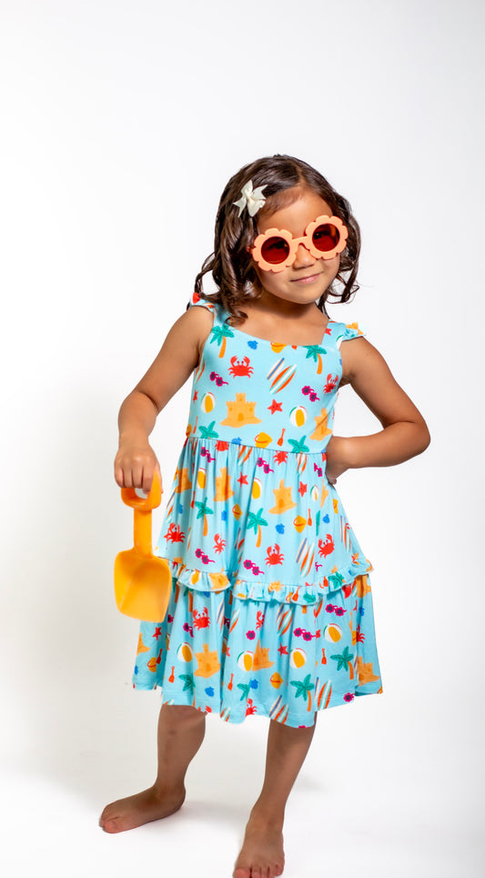 Young girl wearing a colorful dress with a beach theme on a white background