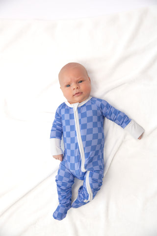 Baby wearing a blue checkered onesie on a white background