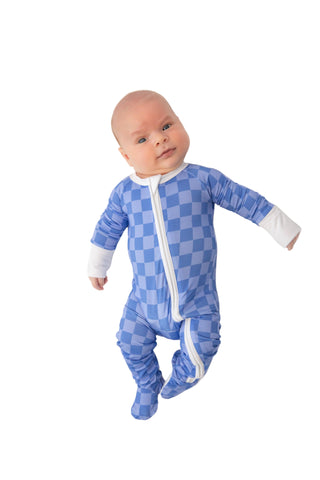 Baby wearing a blue checkered onesie on a white background