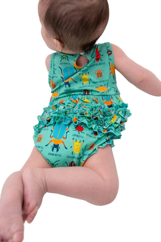 Baby wearing a colorful romper with animal prints on a white background
