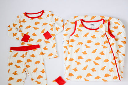 Two baby onesies with orange patterns and red accents on a white background