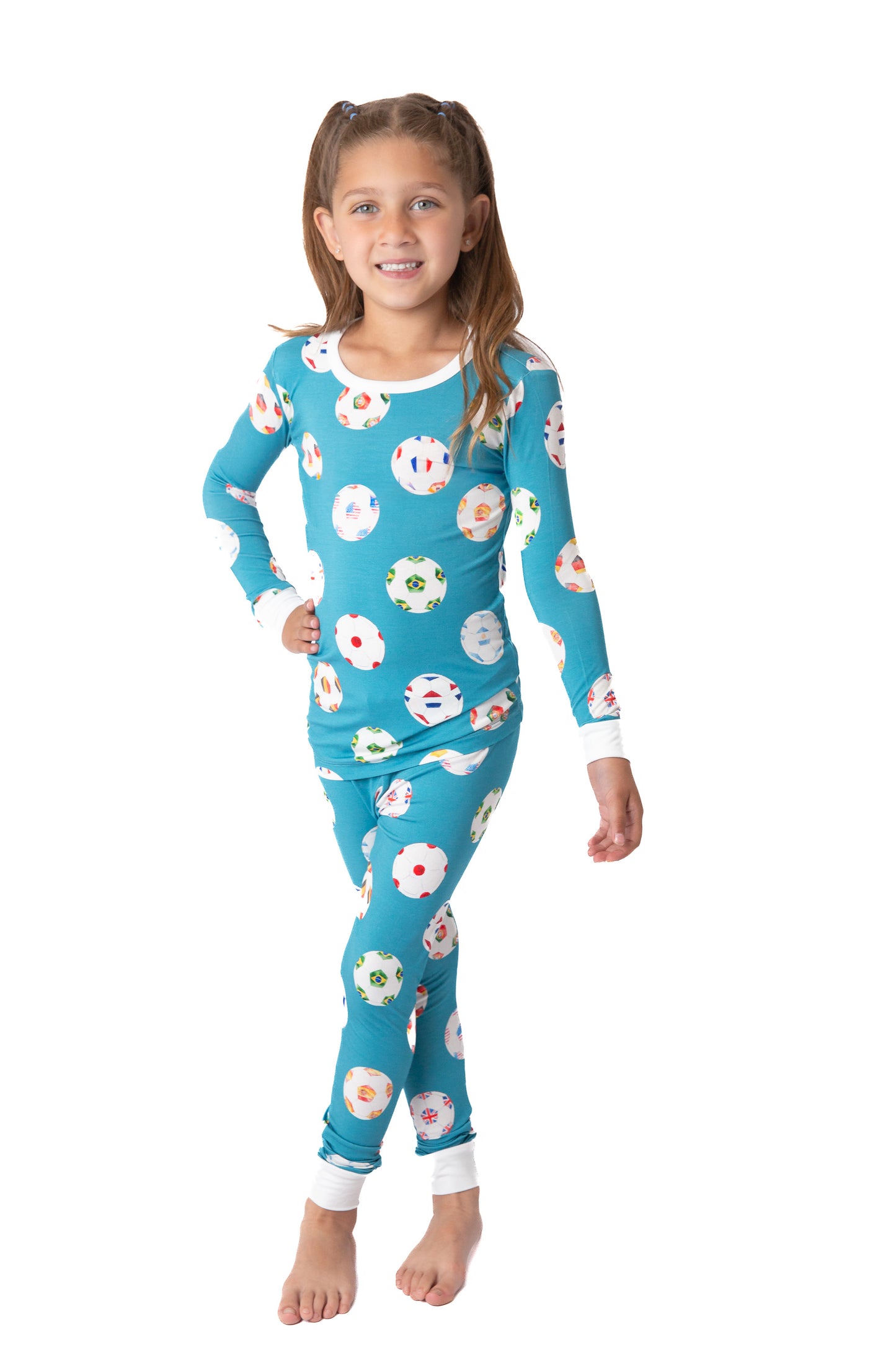 Young girl wearing a blue floral pajama set on a white background