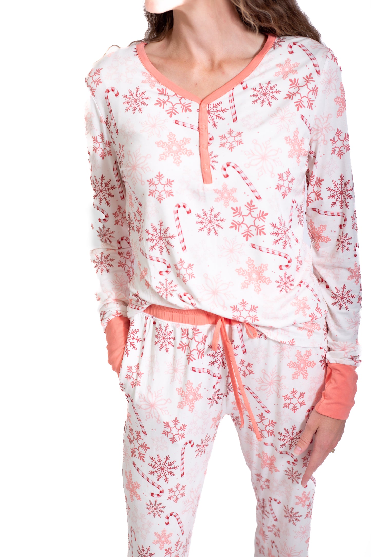 White pajama set with pink floral patterns worn by a person on a white background