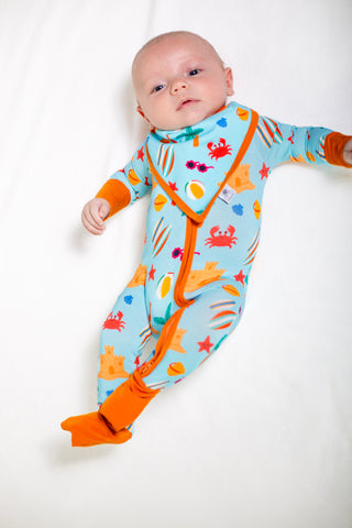 Baby wearing a colorful onesie with sea creature patterns on a white background