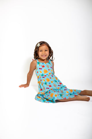Young girl wearing a colorful dress with a white background
