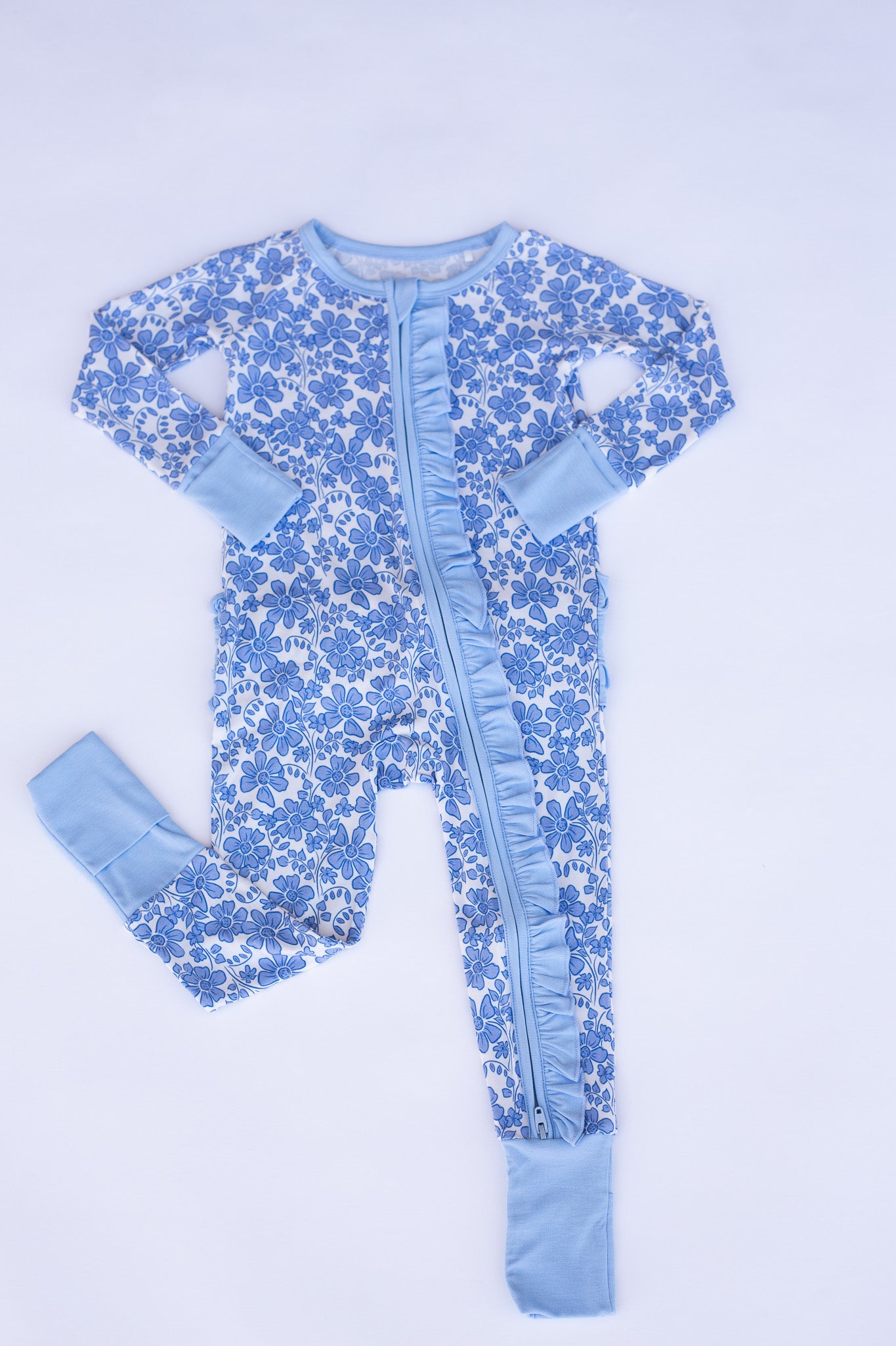 Blue floral baby onesie with legs on a light blue background
