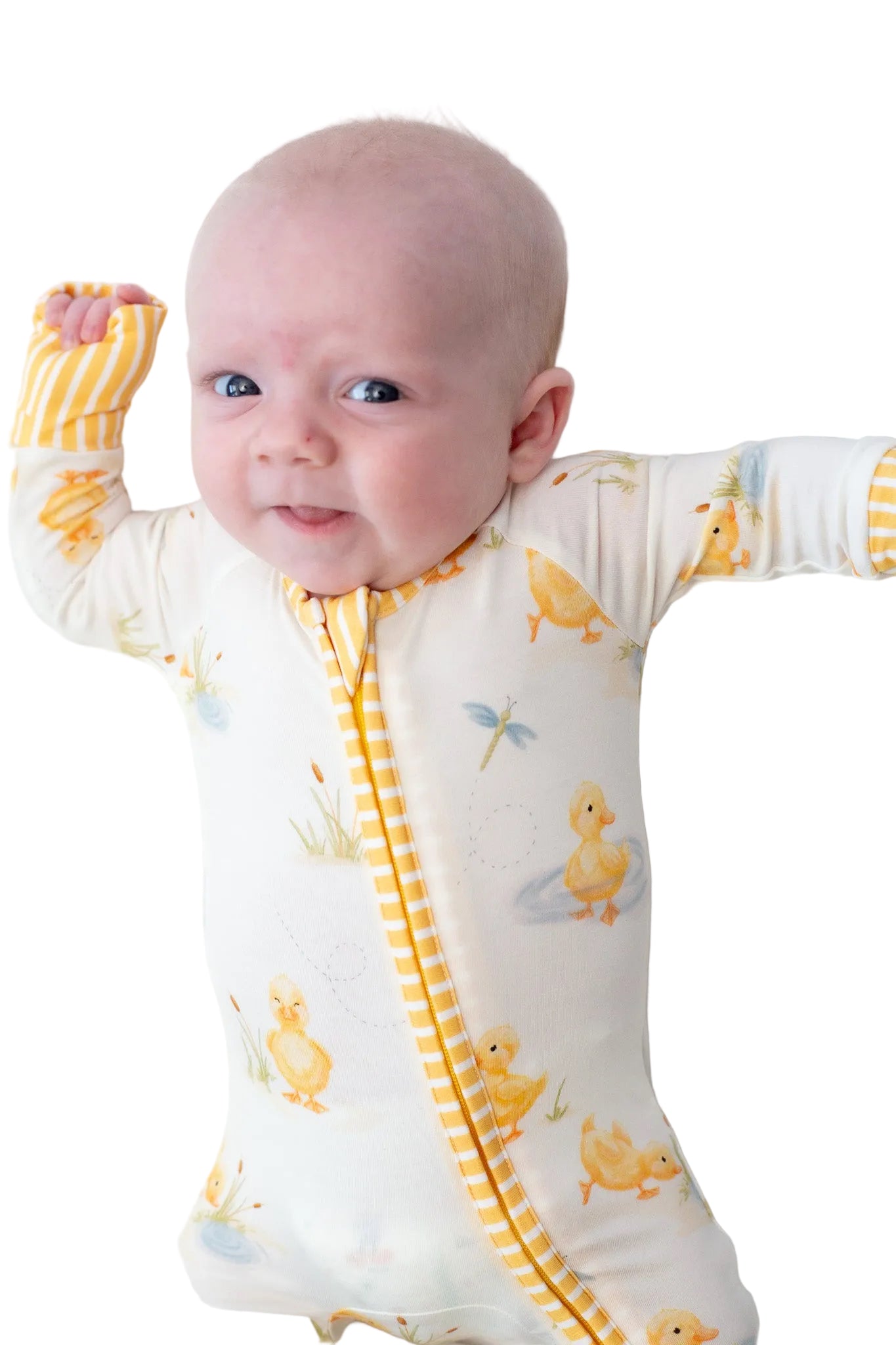 Baby wearing a white onesie with yellow duck patterns on a white background