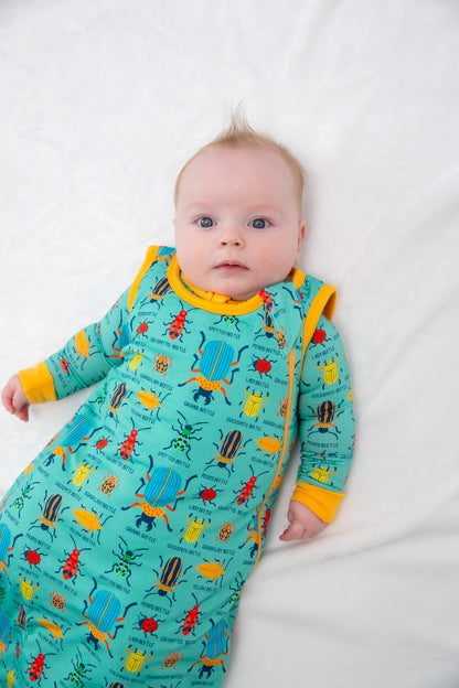 Baby wearing a colorful pajama with insect patterns on a white background