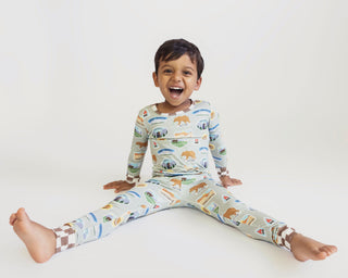 Child wearing pajamas with animal print on a white background