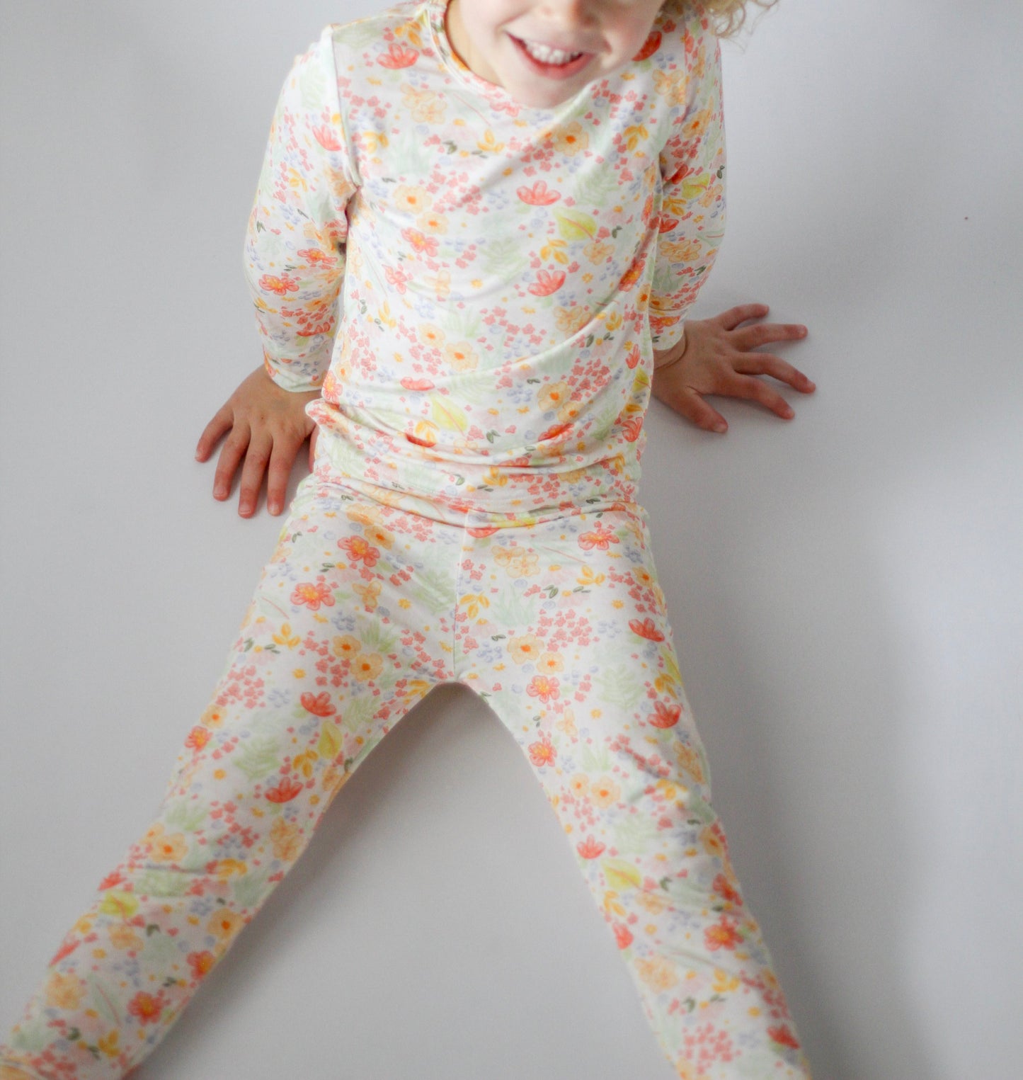 Child wearing a floral outfit on a plain background
