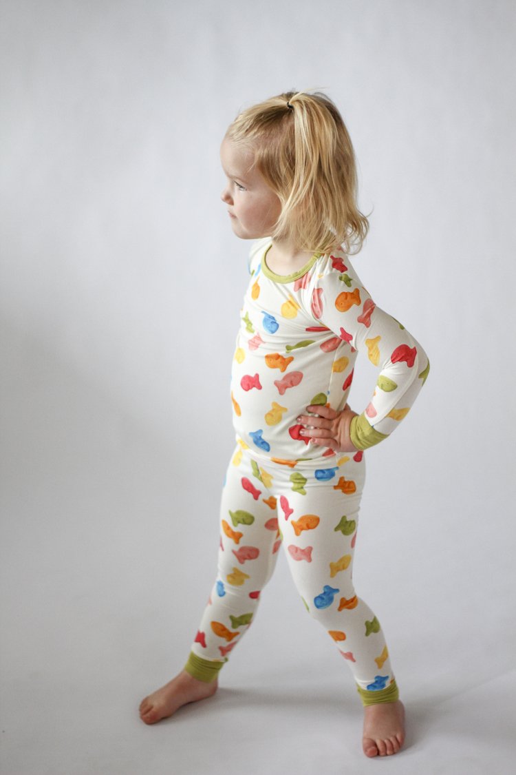 Child wearing a colorful butterfly-themed onesie on a plain background