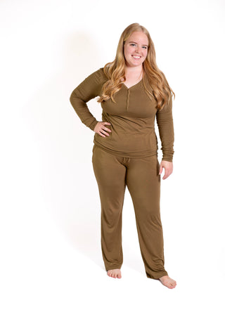Woman wearing a brown long-sleeve top and pants on a white background