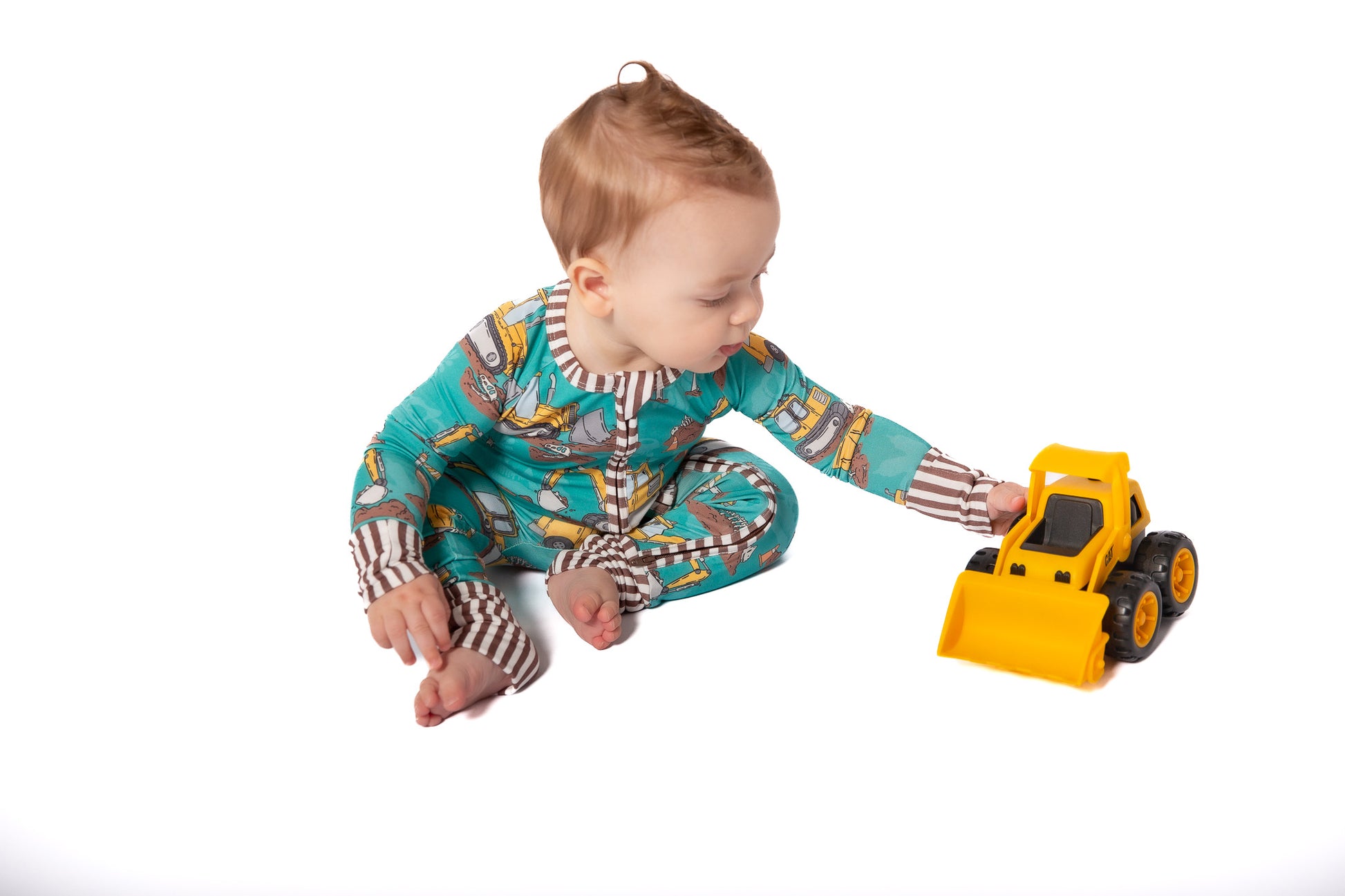 Child playing with a toy bulldozer on a white background