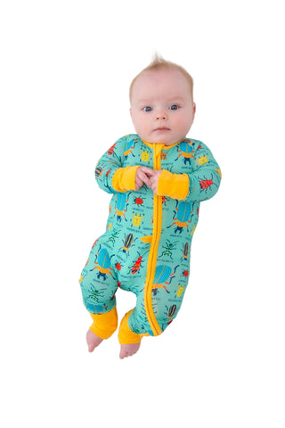 Baby wearing a colorful dinosaur-themed onesie on a white background
