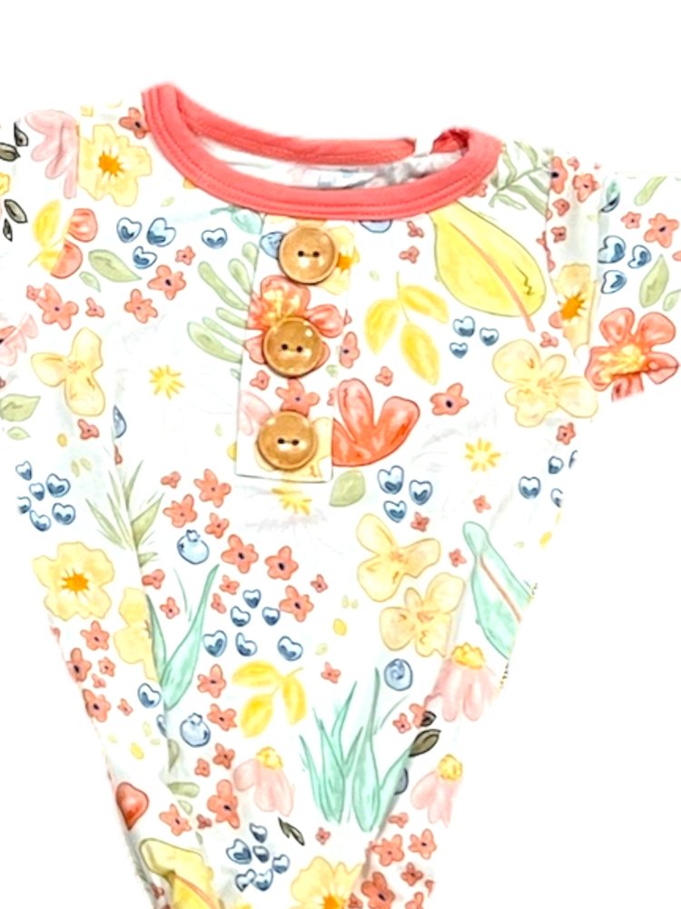 Children's outfit with floral pattern and buttons on a white background