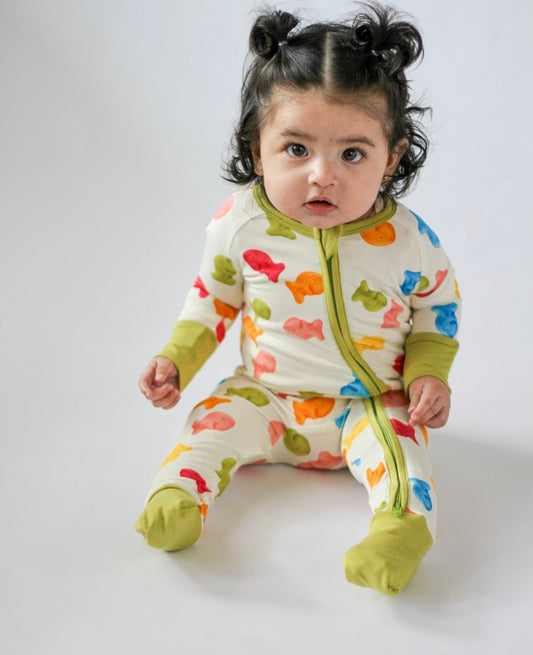 Child wearing a colorful fish-patterned onesie on a plain background