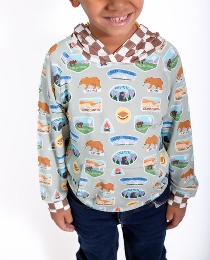 Child wearing a hoodie with nature-themed design on a white background