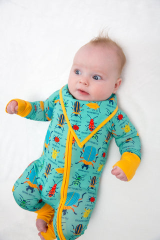 Baby wearing a colorful onesie with a yellow zipper on a white background