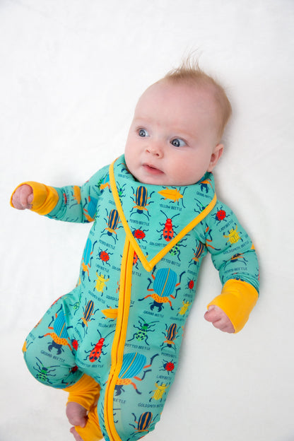 Baby wearing a colorful onesie with a yellow zipper on a white background