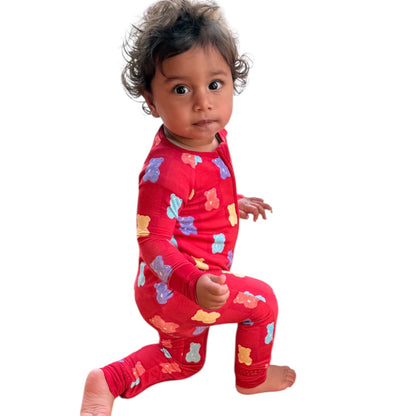 Child wearing a red onesie with colorful bear patterns on a white background
