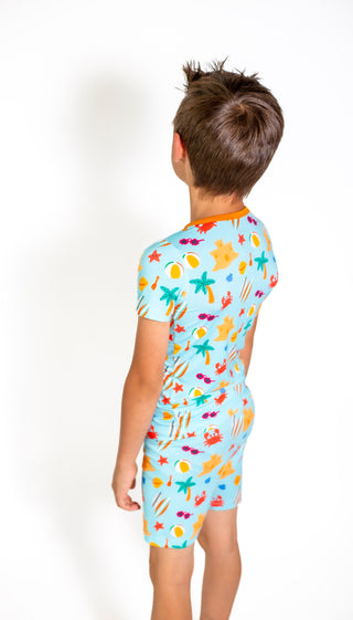 Child wearing a colorful short-sleeve shirt with a pattern on a white background