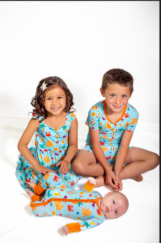 Three children wearing colorful pajamas with cartoon designs on a white background