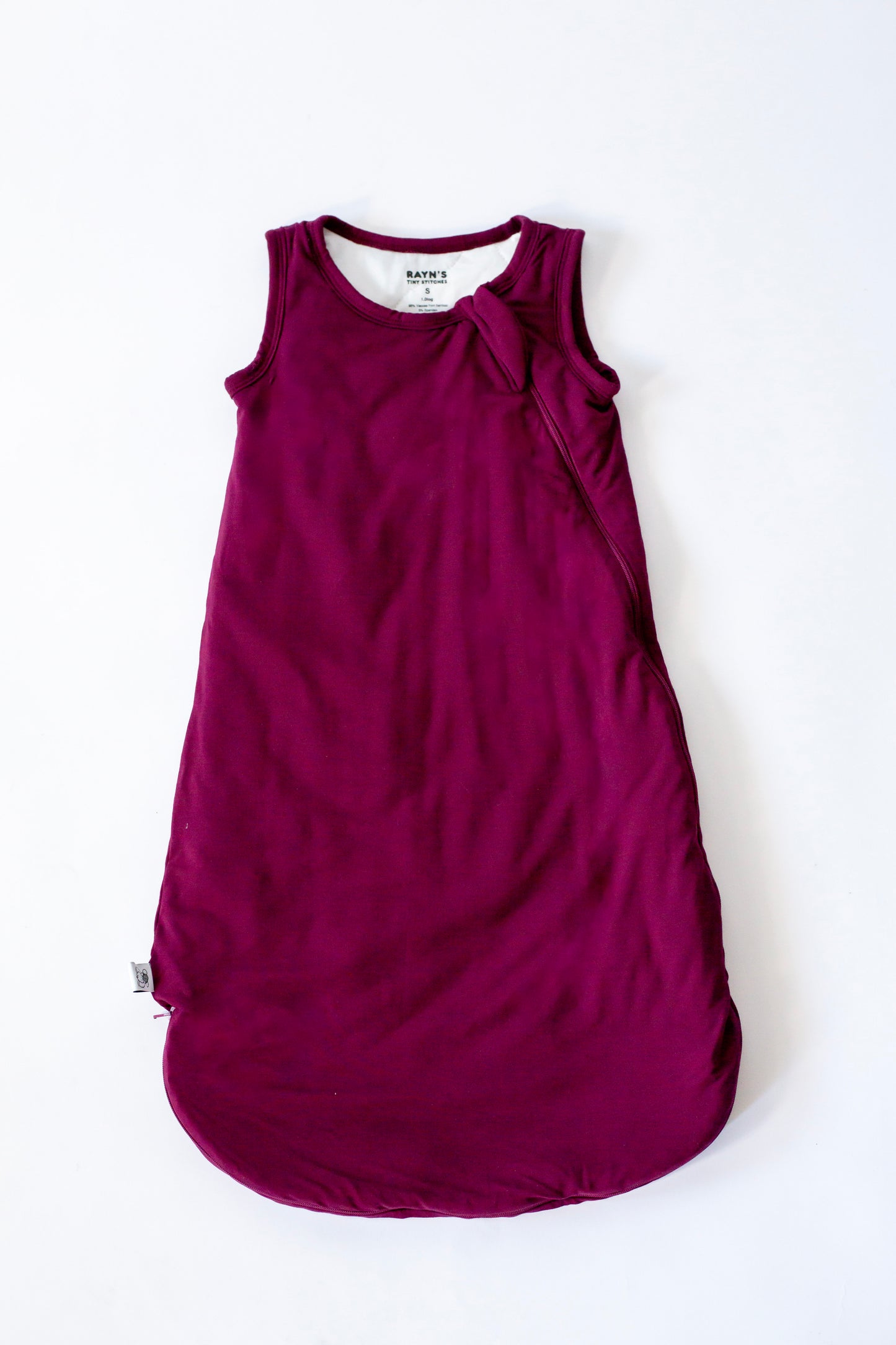 Purple sleeveless dress with a bow detail on a white background