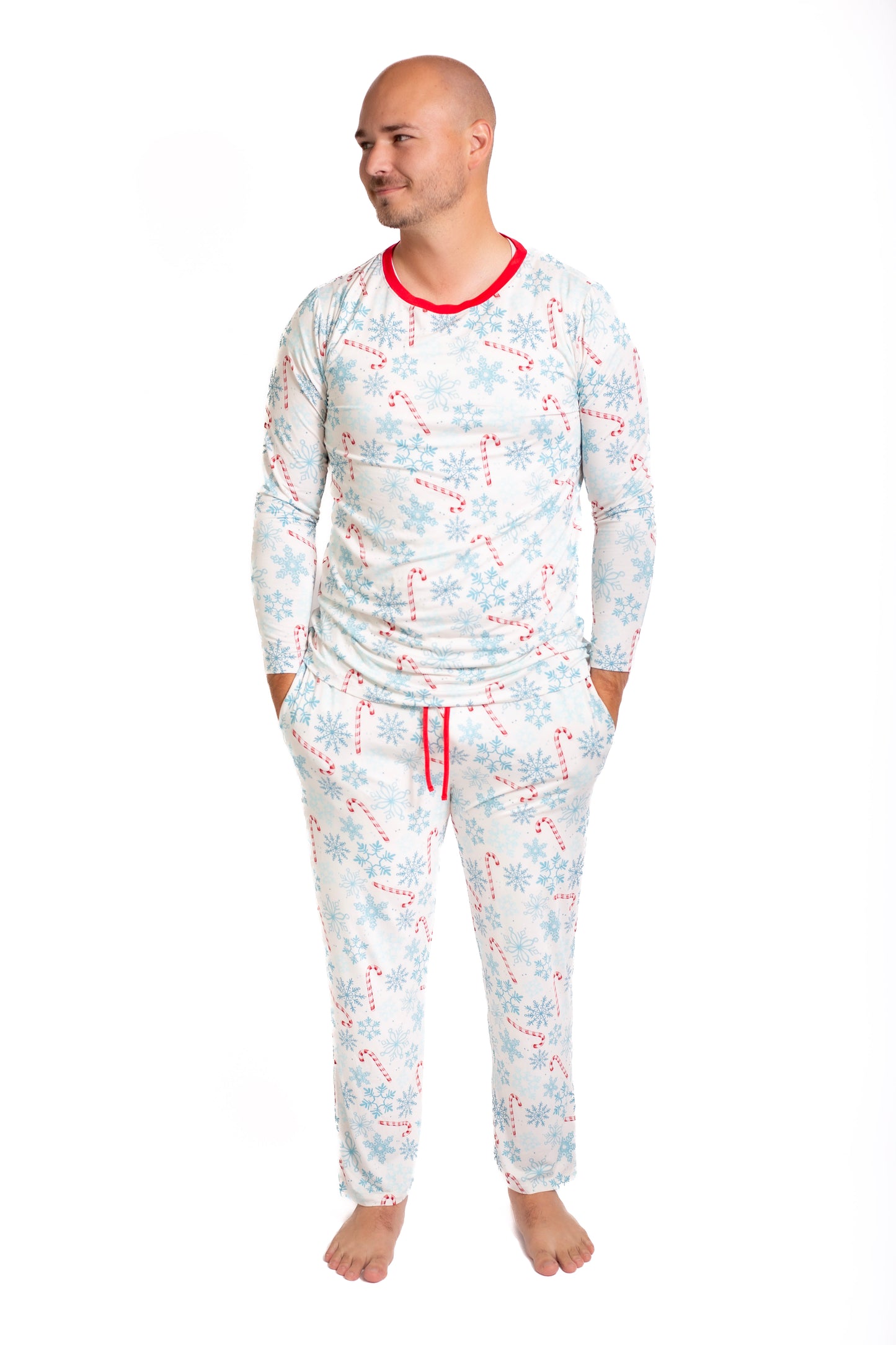 Man wearing a pajama set with candy cane pattern on a white background