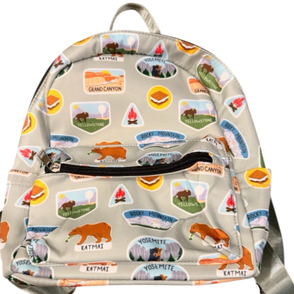 Backpack with nature-themed stickers on a beige background