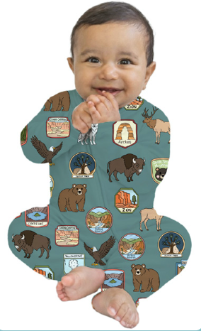 Baby wearing a onesie with nature-themed illustrations on a white background