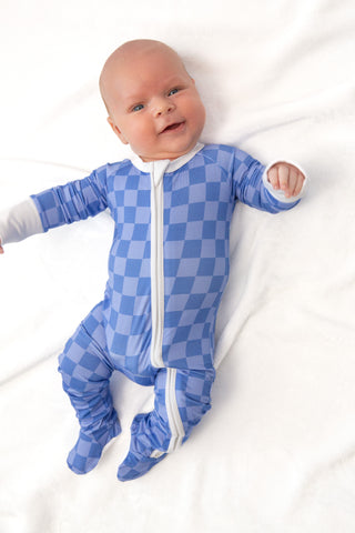 Baby wearing a blue checkered onesie on a white background