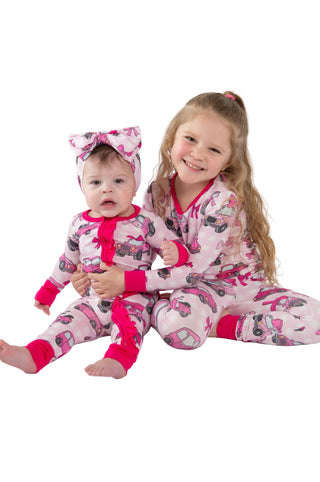 Two children in pink and white pajamas with a butterfly pattern on a white background