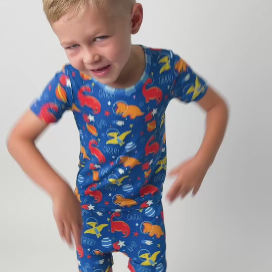 a toddler dancing in his dinosaur short bamboo pajamas that are colorful and butter soft