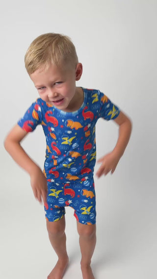 a toddler dancing in his dinosaur short bamboo pajamas that are colorful and butter soft