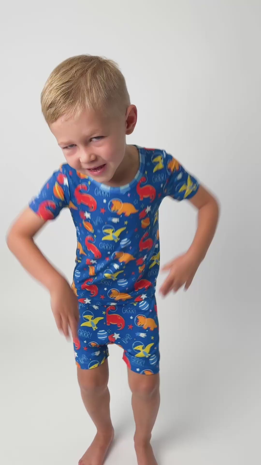 a toddler dancing in his dinosaur short bamboo pajamas that are colorful and butter soft