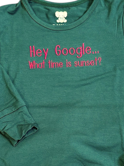 Green t-shirt with pink text 'Hey Google... What time is sunset?' on a white background