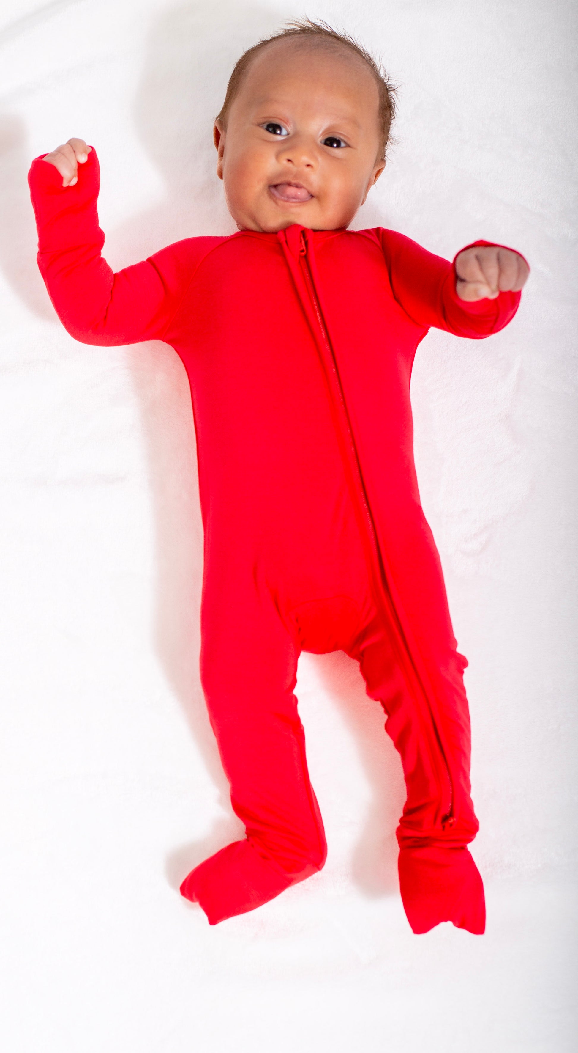 Baby wearing a red onesie on a white background