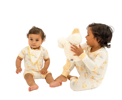 Two children wearing matching pajamas with a white background
