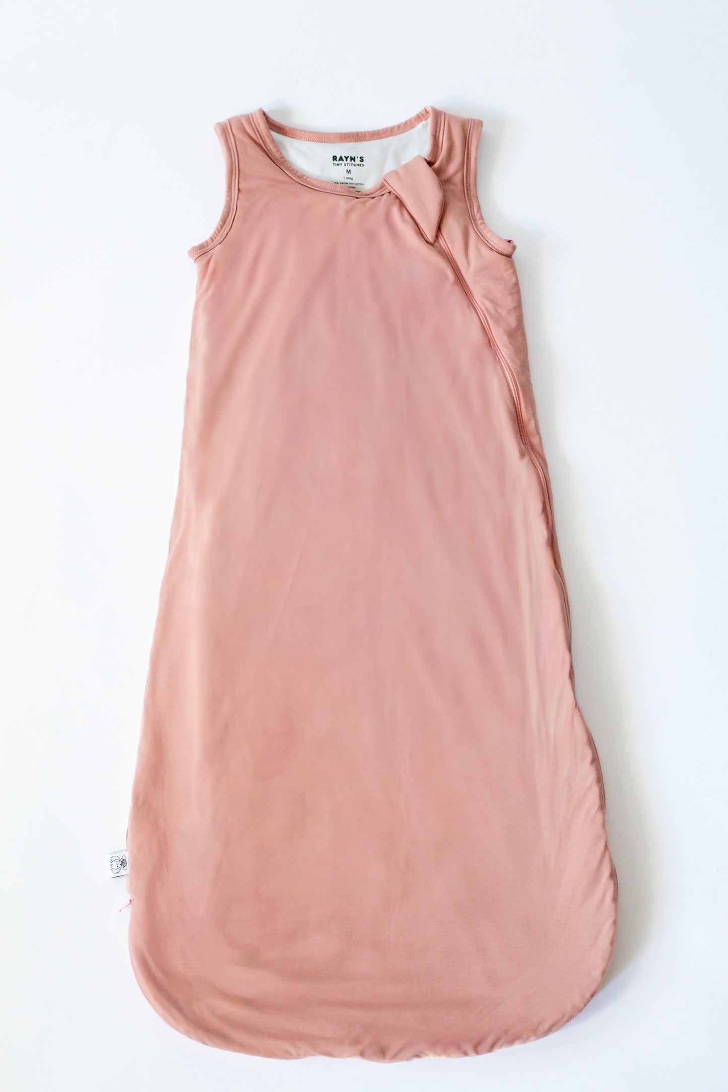 Pink sleeveless dress with a bow on a white background