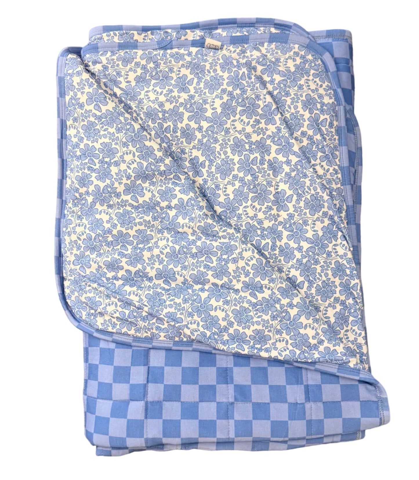 Folded blue and white checkered blanket on a beige carpet