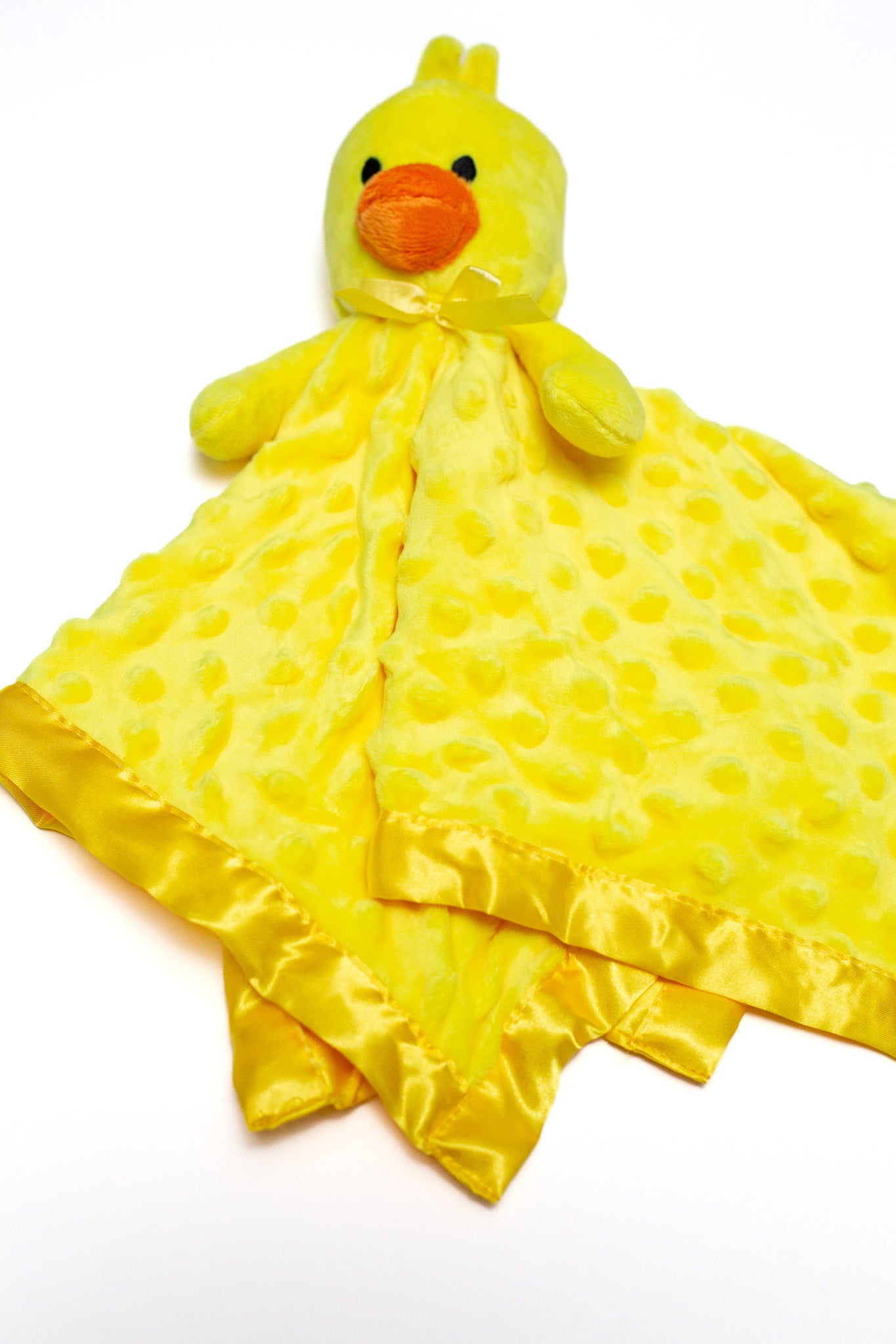 Yellow duck plush toy with a blanket on a white background