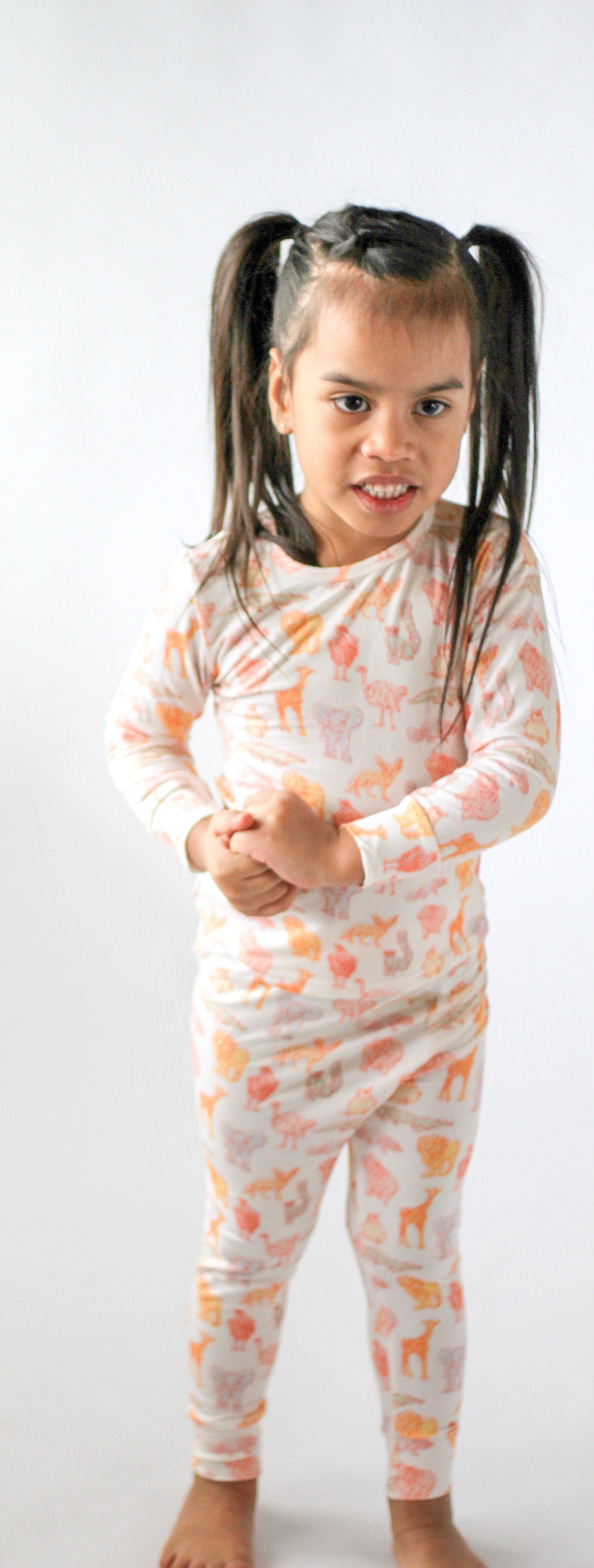 Child wearing a patterned onesie on a white background