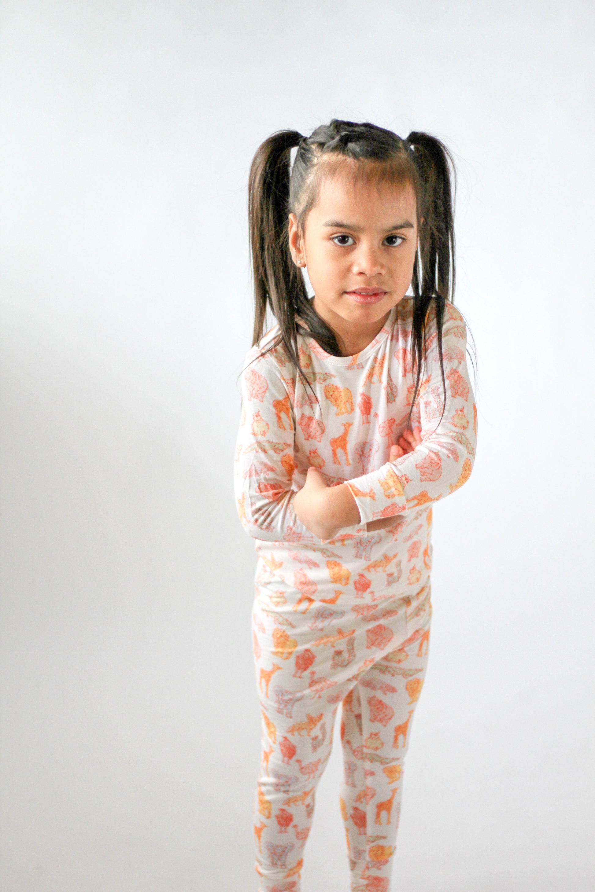 Young girl wearing a patterned outfit on a white background